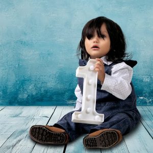 Fotografía de estudio de un niño de un año en su sesión de fotos de primer cumpleaños. Viste ropa cómoda y posa con naturalidad. Ideal para álbumes de recuerdos. Fotografía por Click Fotografía.