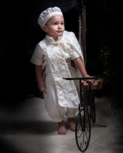Retrato de un niño en su sesión de fotos infantil. Viste ropa colorida y juega con juguetes. Fondo temático de estudio. Fotografía profesional por Click Fotografía.